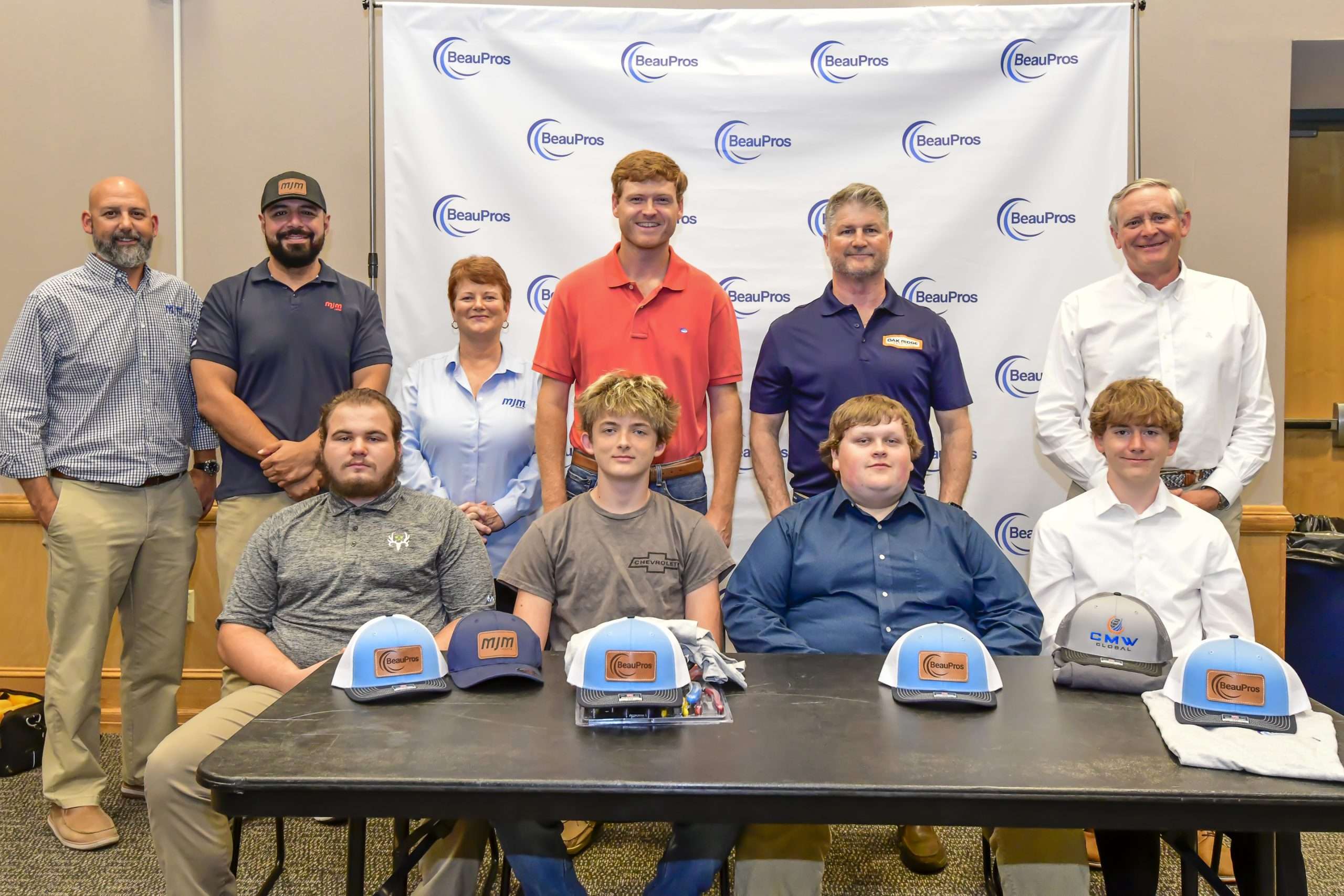 two rows of people, hats on a table
