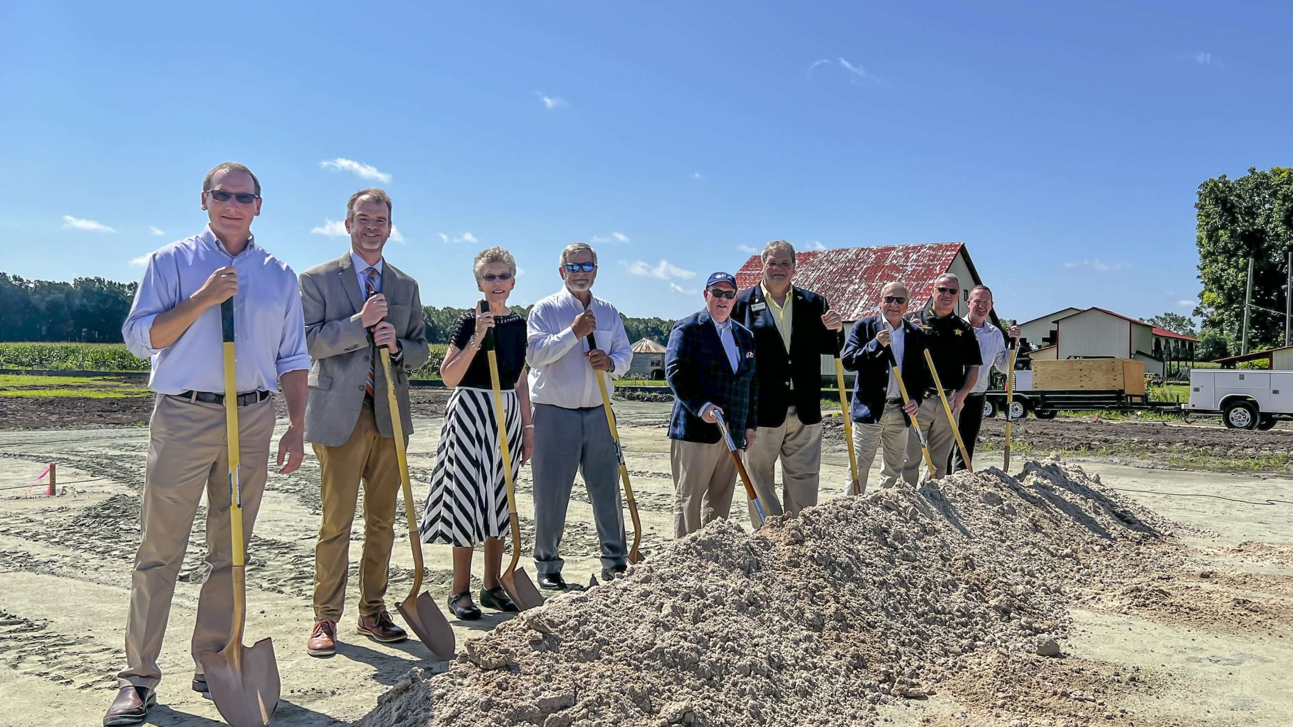 people behind a dirt pile with shovels