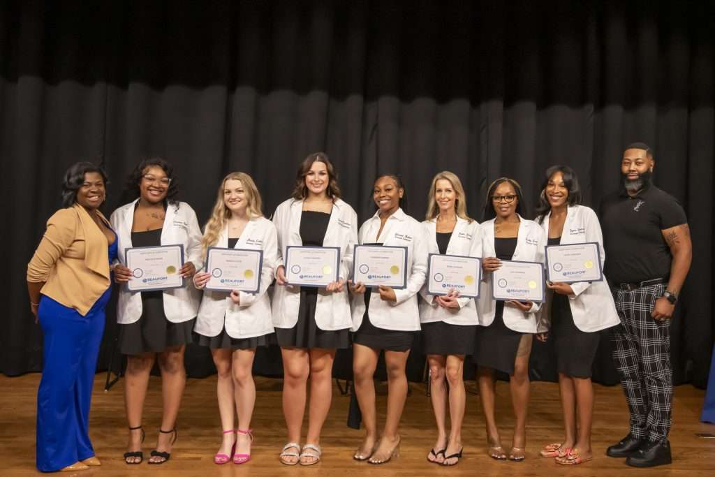 group in white coats on stage