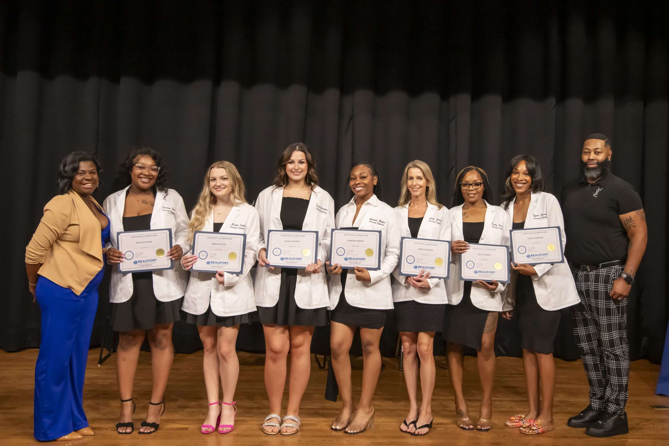 group in white coats on stage