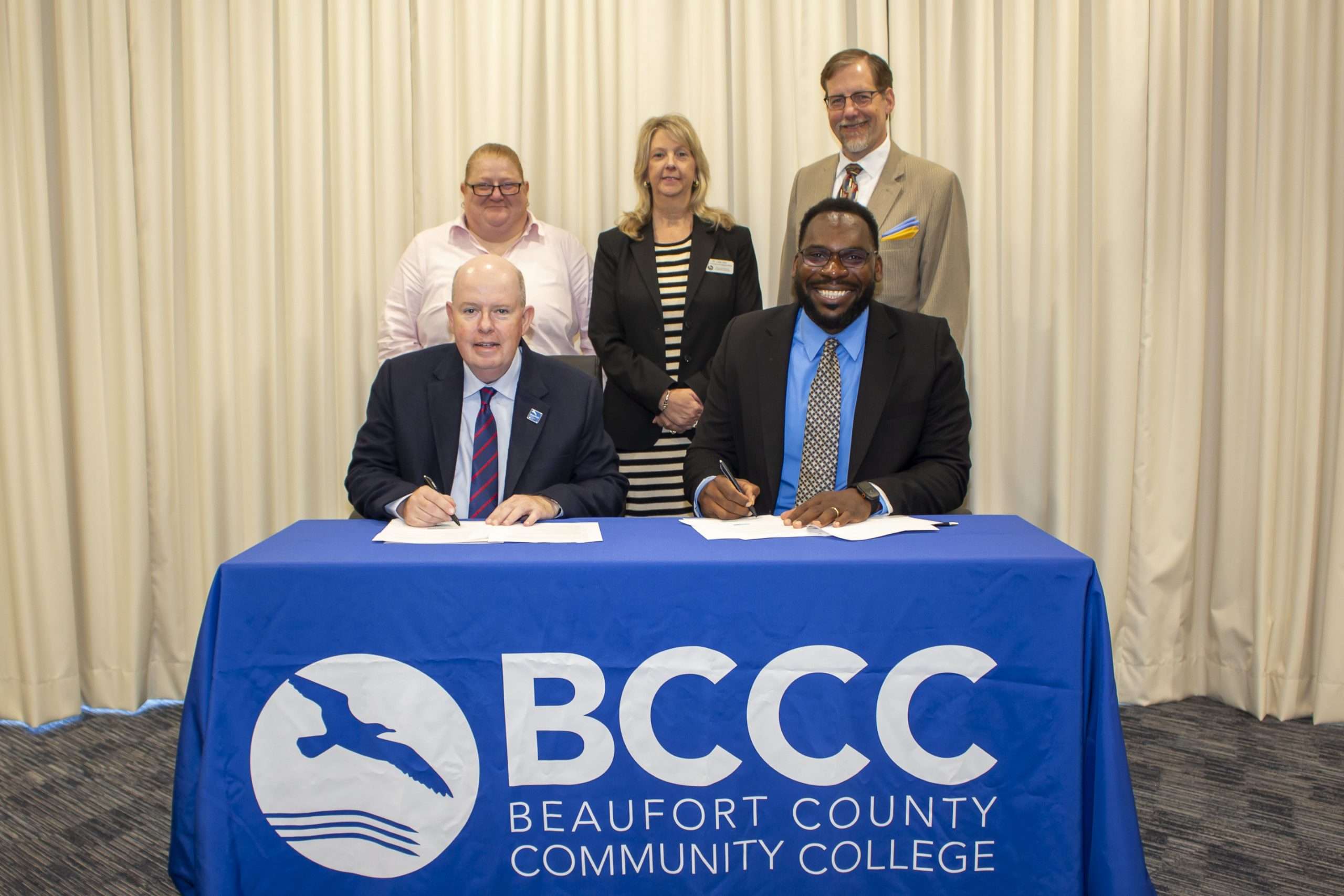 people behind a table with BCCC logo