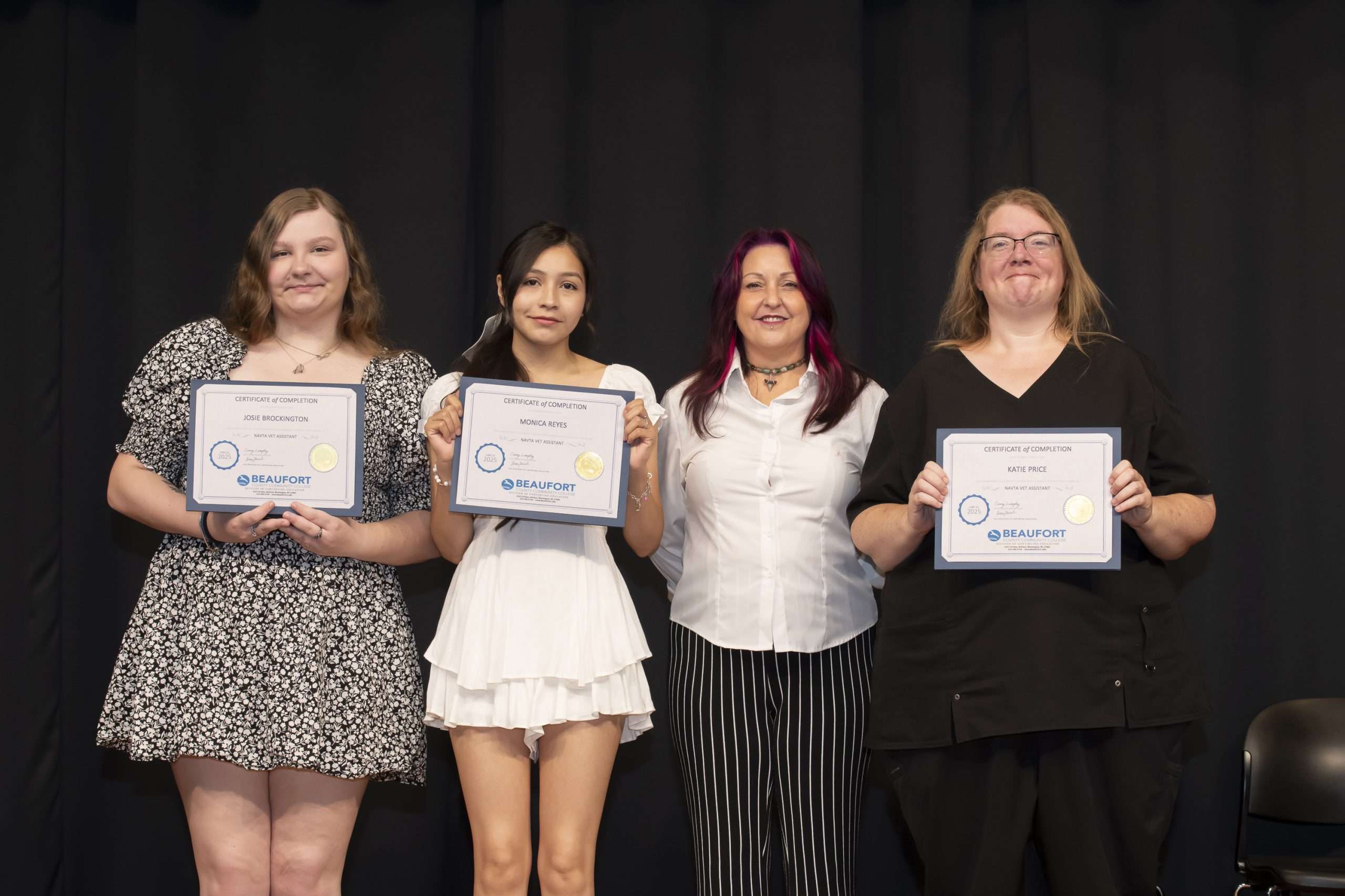 four people with certificates