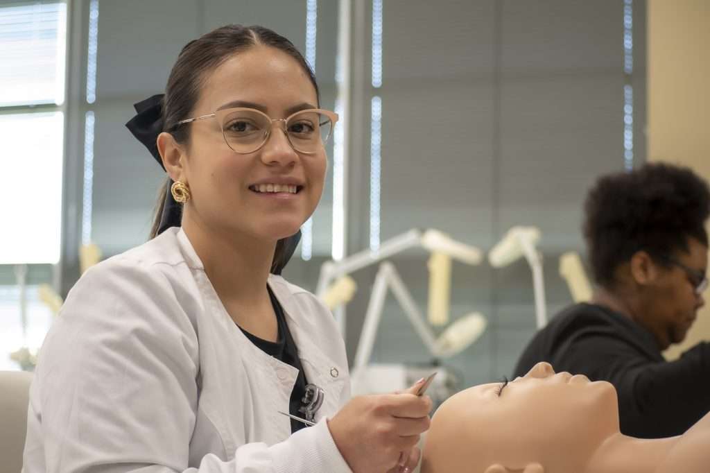 Woman doing makeup on a mannequin