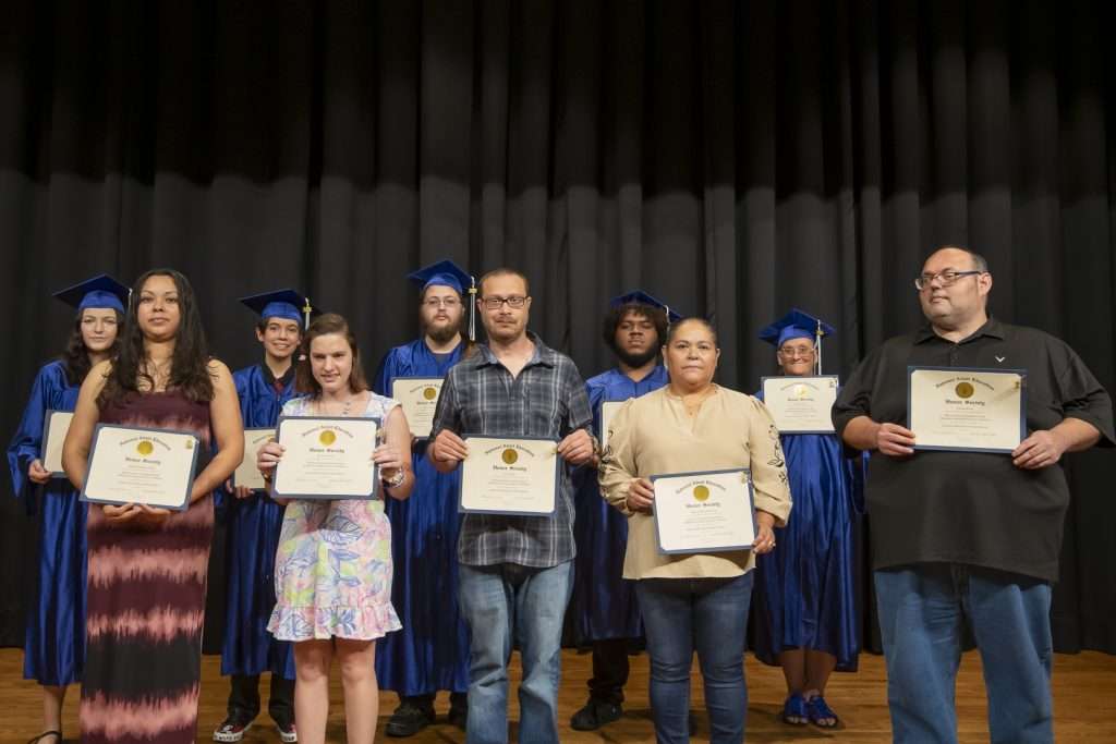 Group on a stage holding certificates