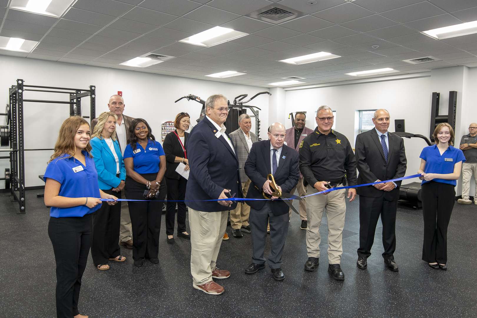 Group cutting a ribbon inside a room