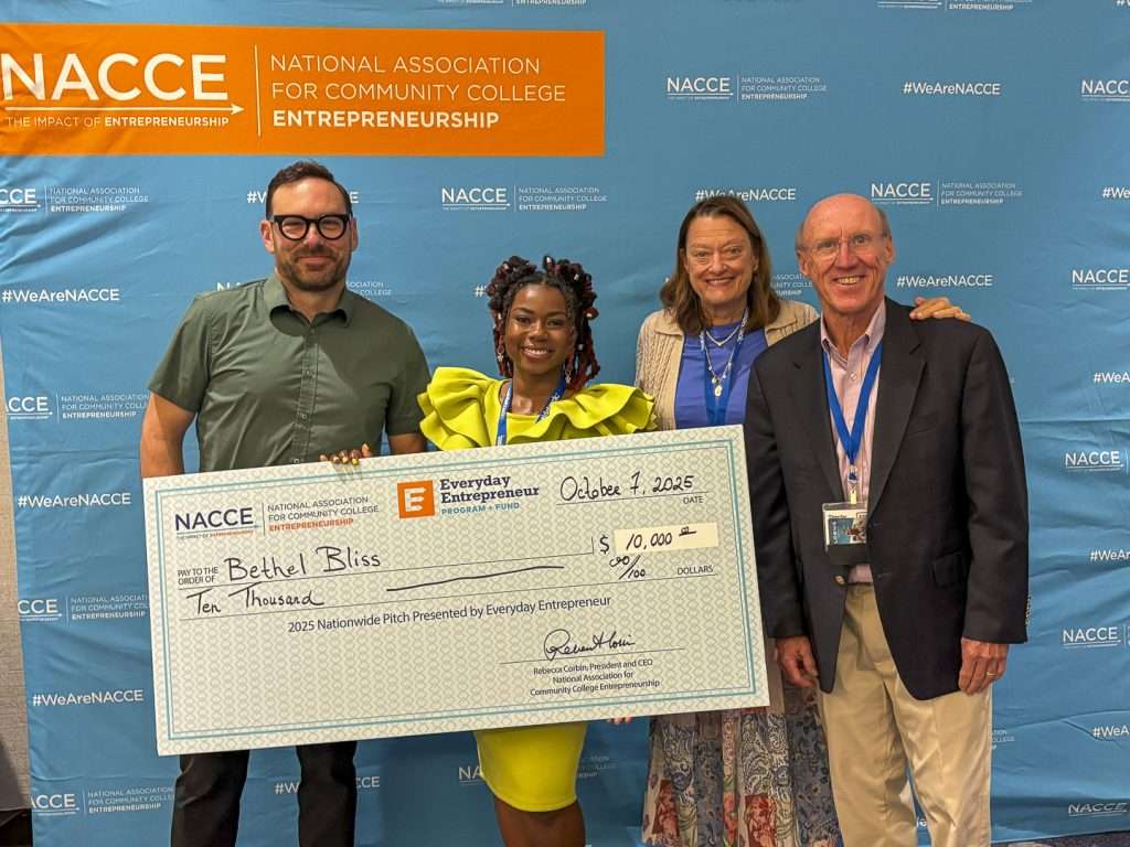 four people with a big check