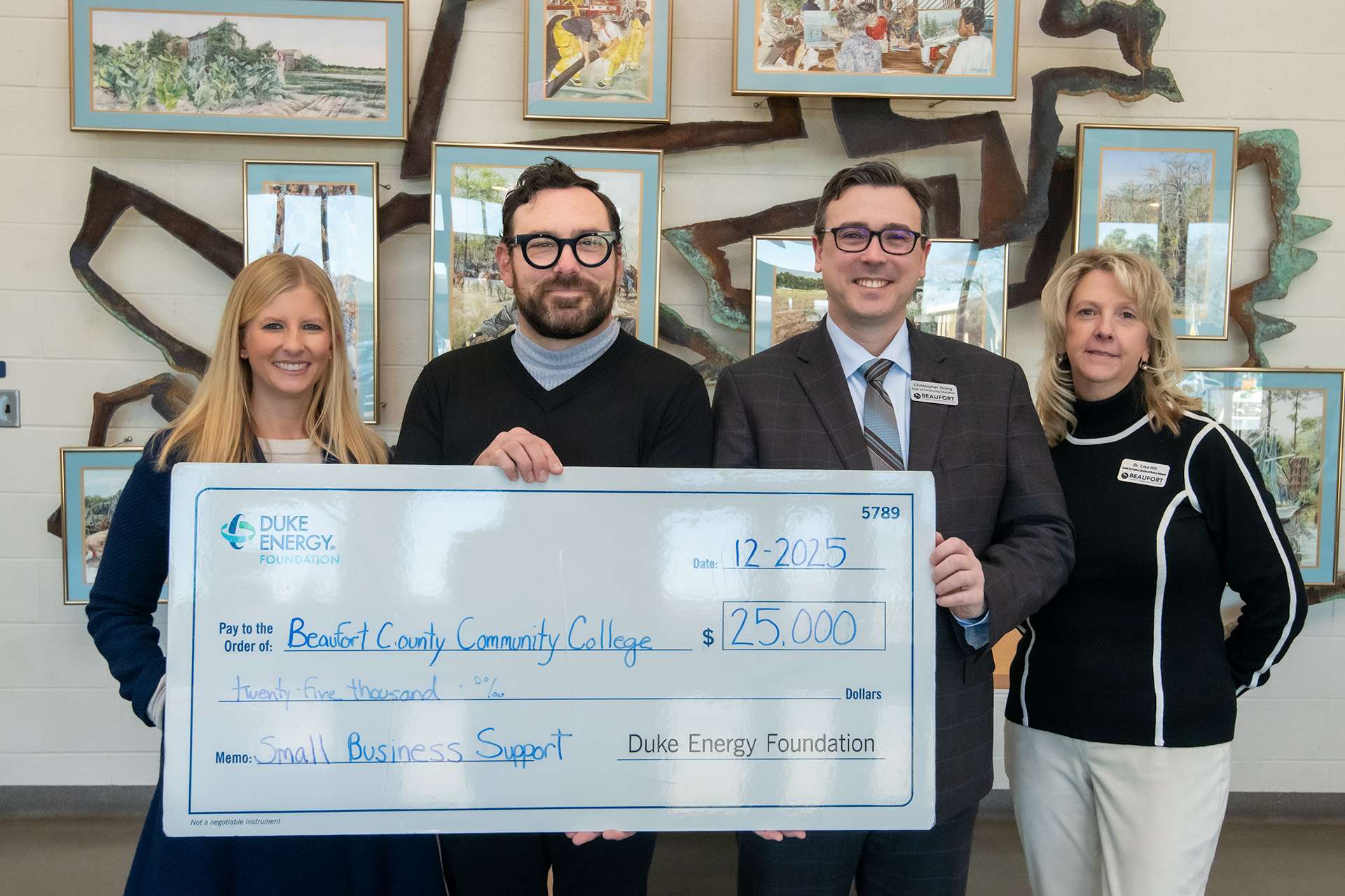 four people with a large check