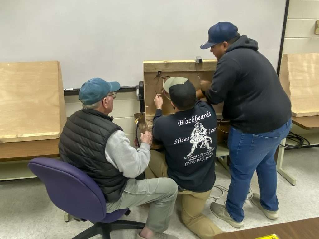 three people rigging equipment