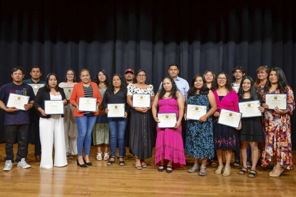 Group on stage holding certificates