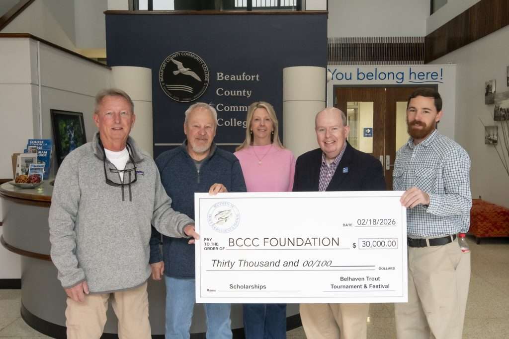 five people with a large check