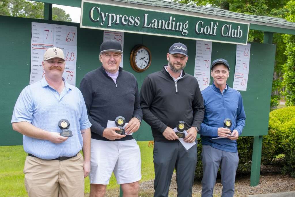 Four people in front of sign reading Cypress Landing Golf Club
