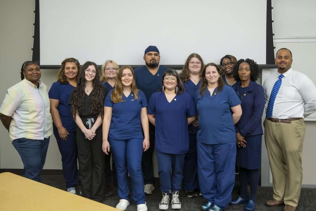 Group of people in navy scrubs.