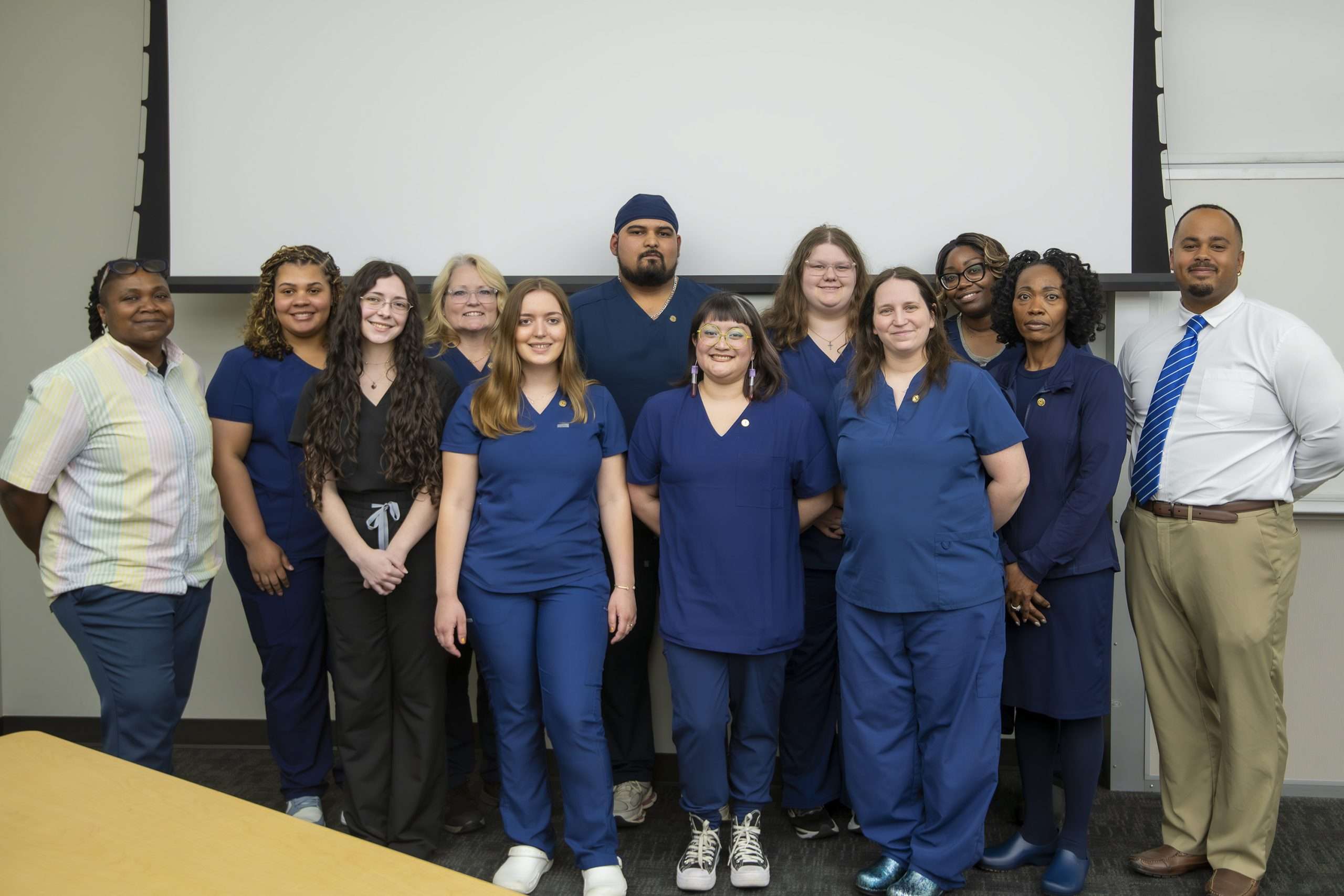 Group of people in navy scrubs.