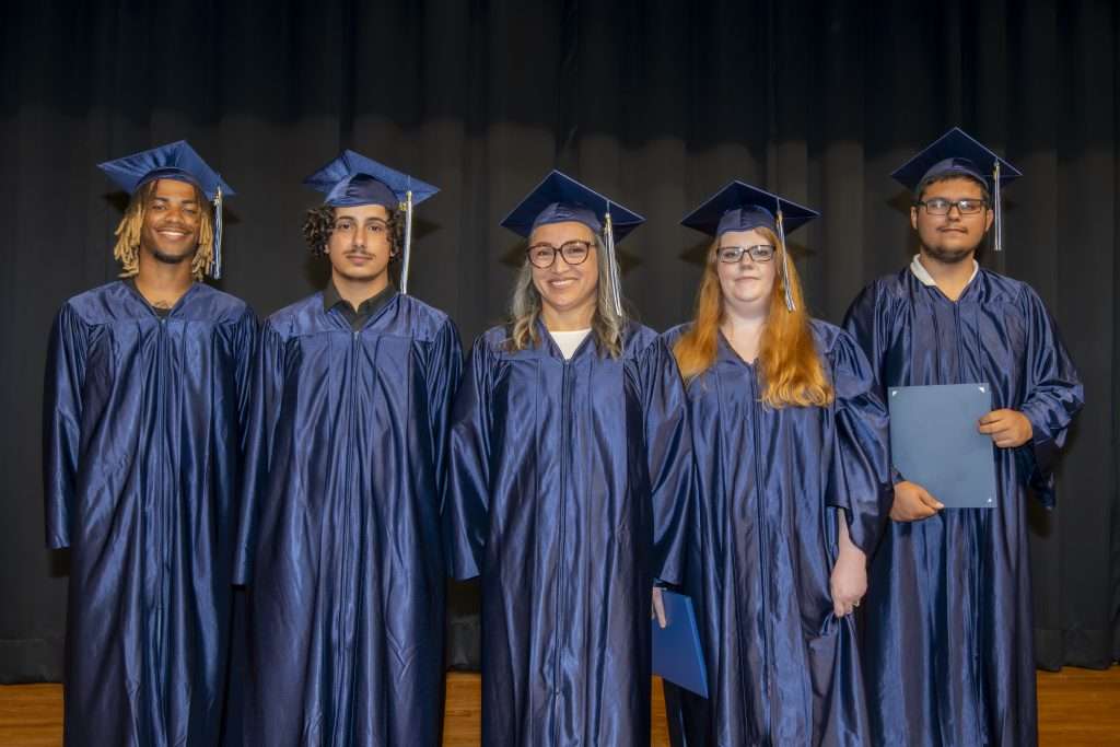 Group on stage in cap & gown